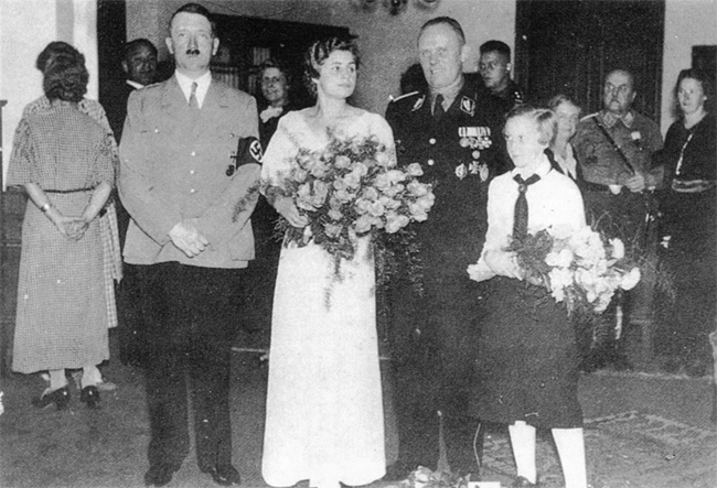 In the Führer's private apartment in Munich, Adolf Hitler pose as the best man at his pilot Hans Baur's wedding